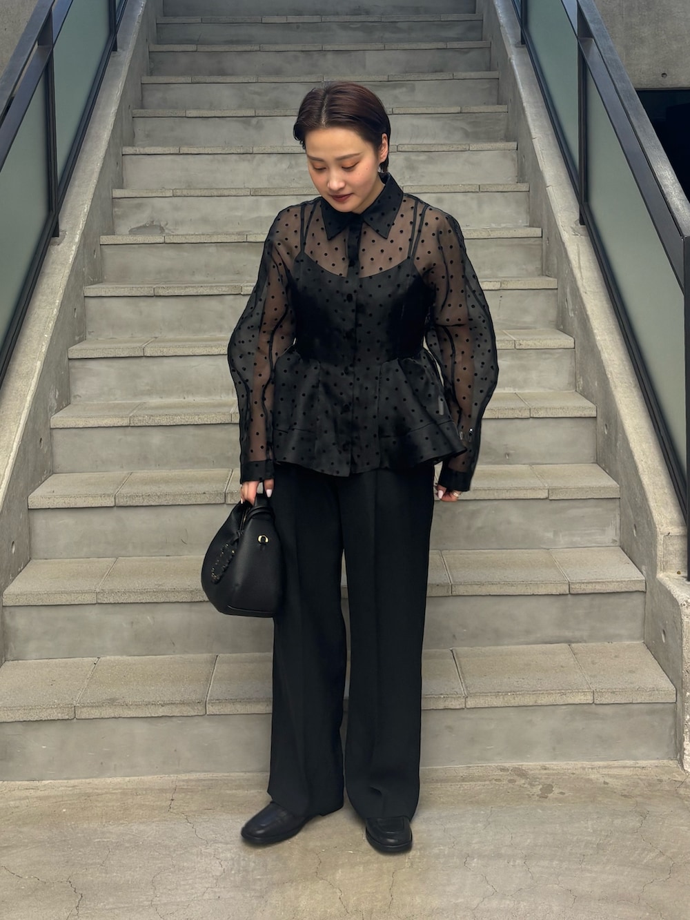 ブラック系のその他パンツ、ブラック系のシャツ/ブラウス、ブラック系のハンドバッグを着用したレディースの春コーディネートの2枚目の写真