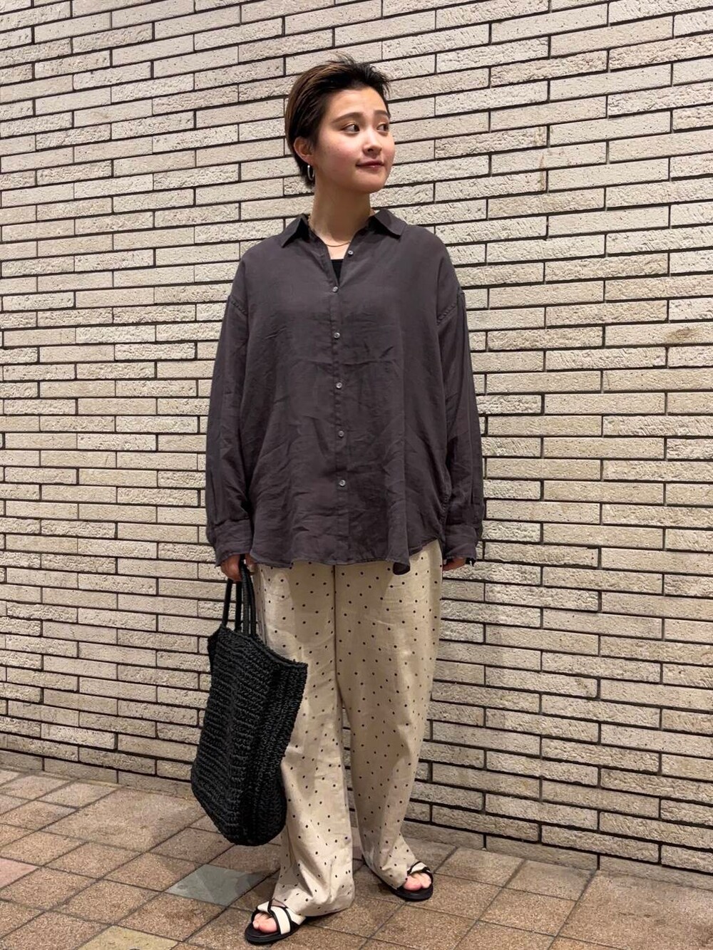 ブラック系のトートバッグ、ホワイト系のサンダル、ベージュ系のその他パンツを着用したレディースの夏コーディネートの3枚目の写真