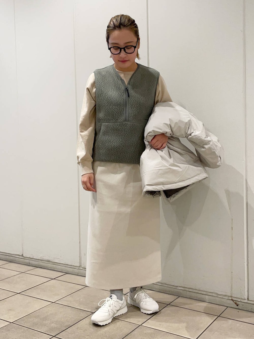 ベージュ系のTシャツ/カットソー、ホワイト系のダウンジャケット/コート、ホワイト系のスカートを着用したレディースの冬コーディネートの4枚目の写真