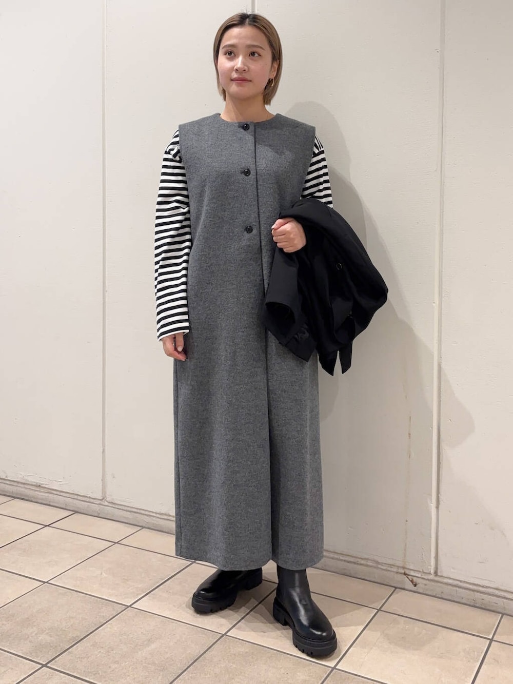 ブラック系のブーツ、ブラック系のTシャツ/カットソー、ブラック系のその他アウターを着用したレディースの冬コーディネートの5枚目の写真