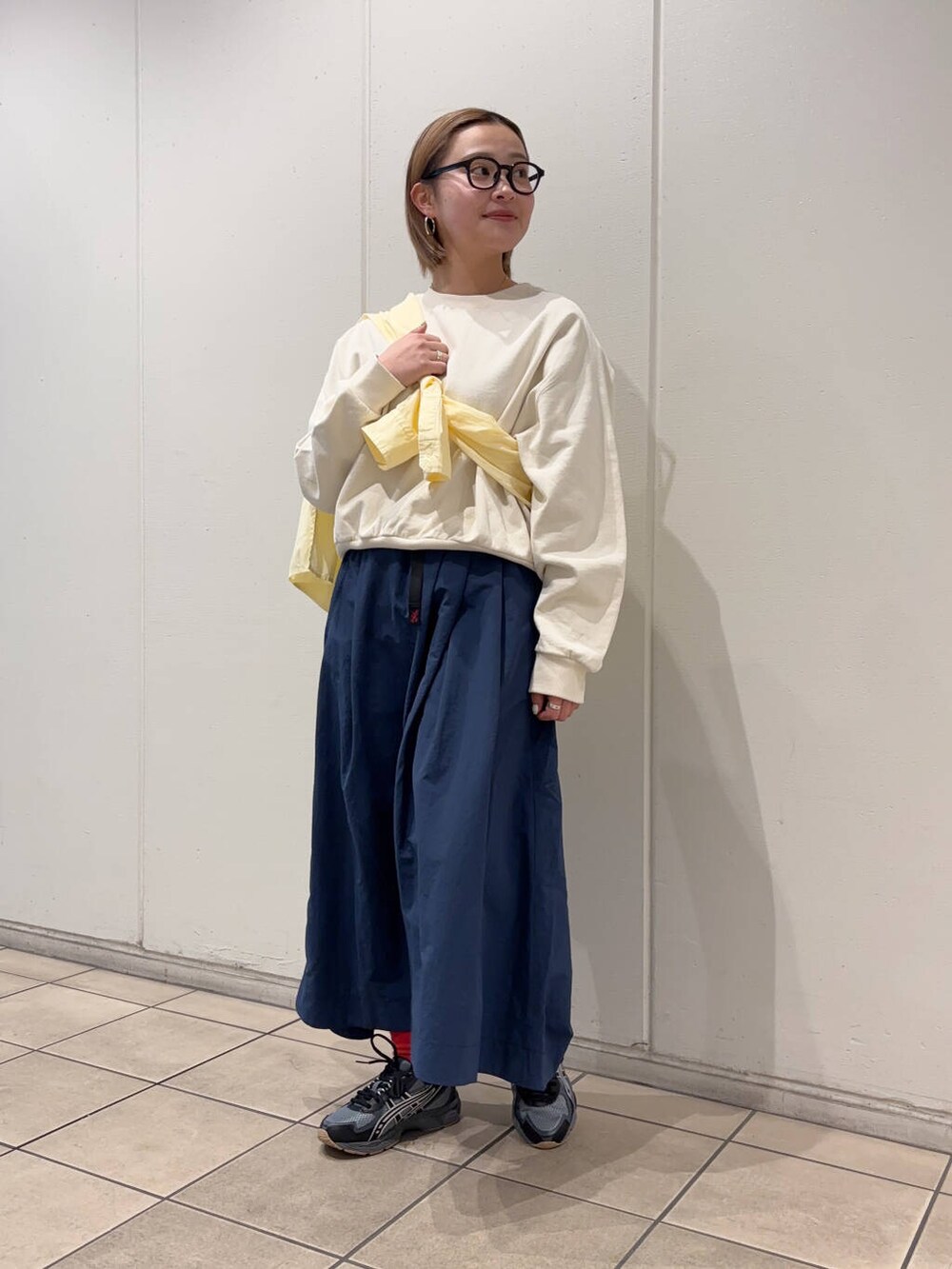 イエロー系のシャツ/ブラウス、ホワイト系のスウェット、ブラック系のスニーカーを着用したレディースの春コーディネートの2枚目の写真