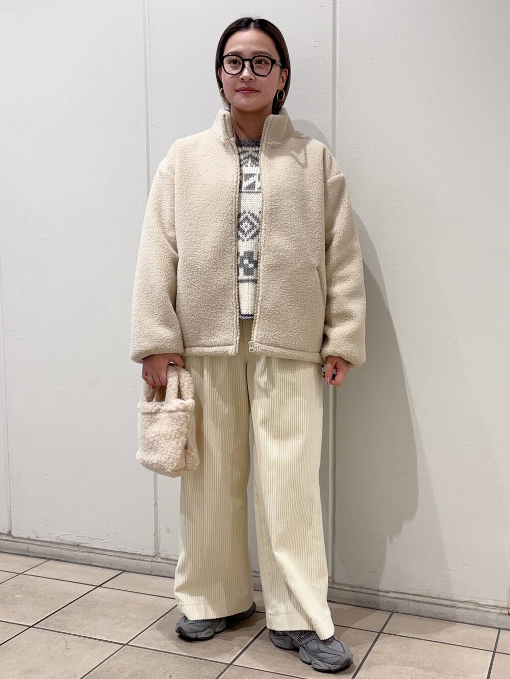 ベージュ系のハンドバッグ、ホワイト系のブルゾン、ホワイト系のその他パンツを着用したレディースの冬コーディネートの2枚目の写真