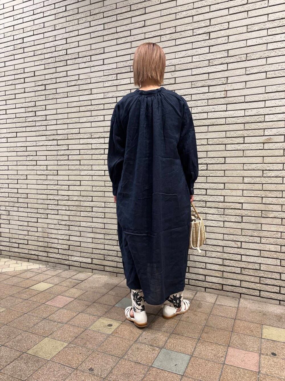 ブルー系のワンピース、ホワイト系のサンダル、グレー系のハンドバッグを着用したレディースの春コーディネートの4枚目の写真