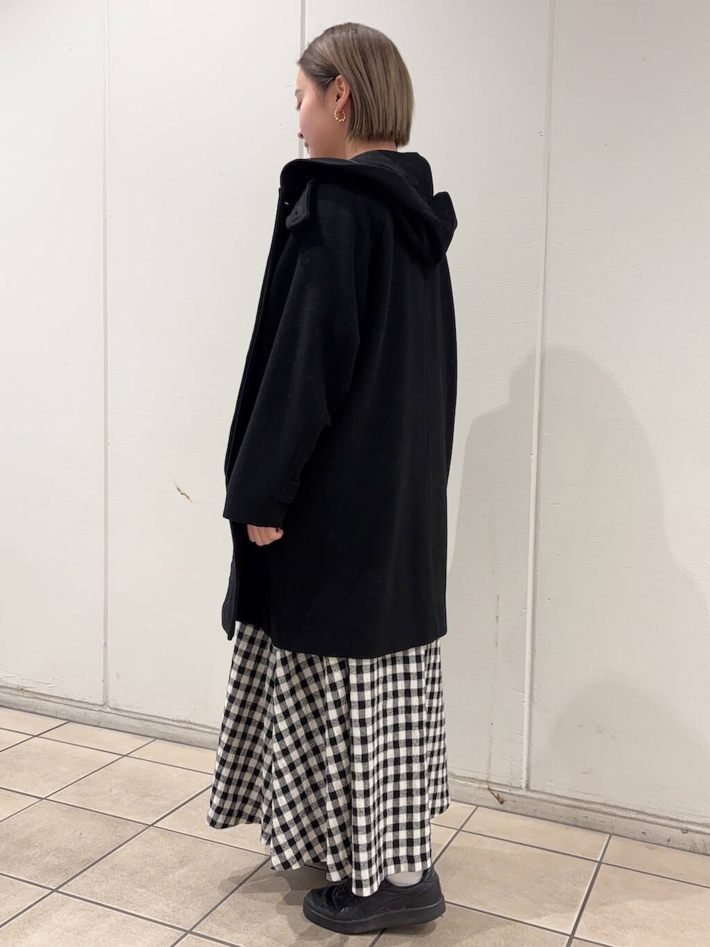 ホワイト系のスカート、ブラック系のその他アウター、ブラック系のニット/セーターを着用したレディースの冬コーディネートの3枚目の写真