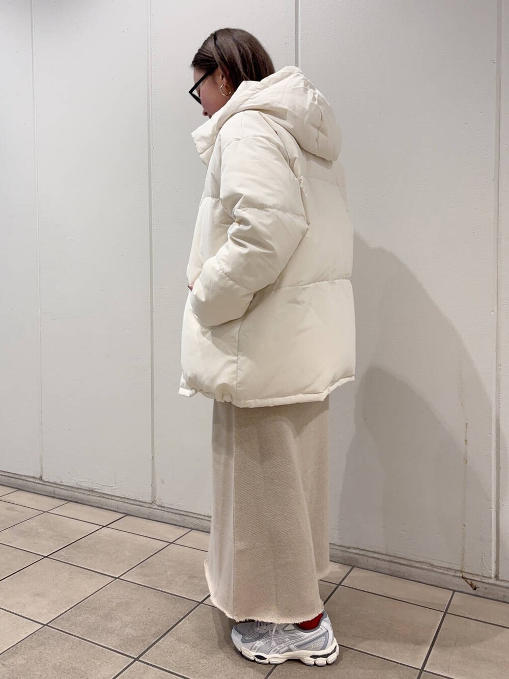 ベージュ系のTシャツ/カットソー、ベージュ系のスカート、ホワイト系のダウンジャケット/コートを着用したレディースの冬コーディネートの3枚目の写真