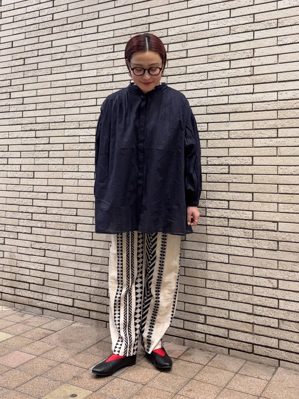 ブラック系のパンプス、ベージュ系のその他パンツ、ブルー系のシャツ/ブラウスを着用したレディースの春コーディネートの2枚目の写真