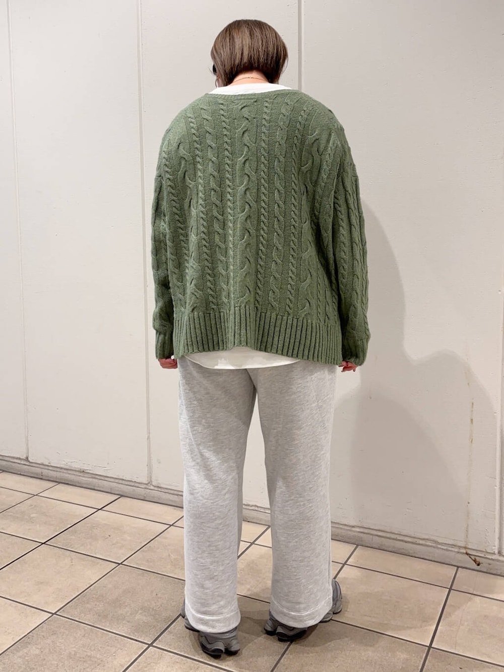 グリーン系のニット/セーター、ホワイト系のTシャツ/カットソー、グレー系のその他パンツを着用したレディースの冬コーディネートの3枚目の写真