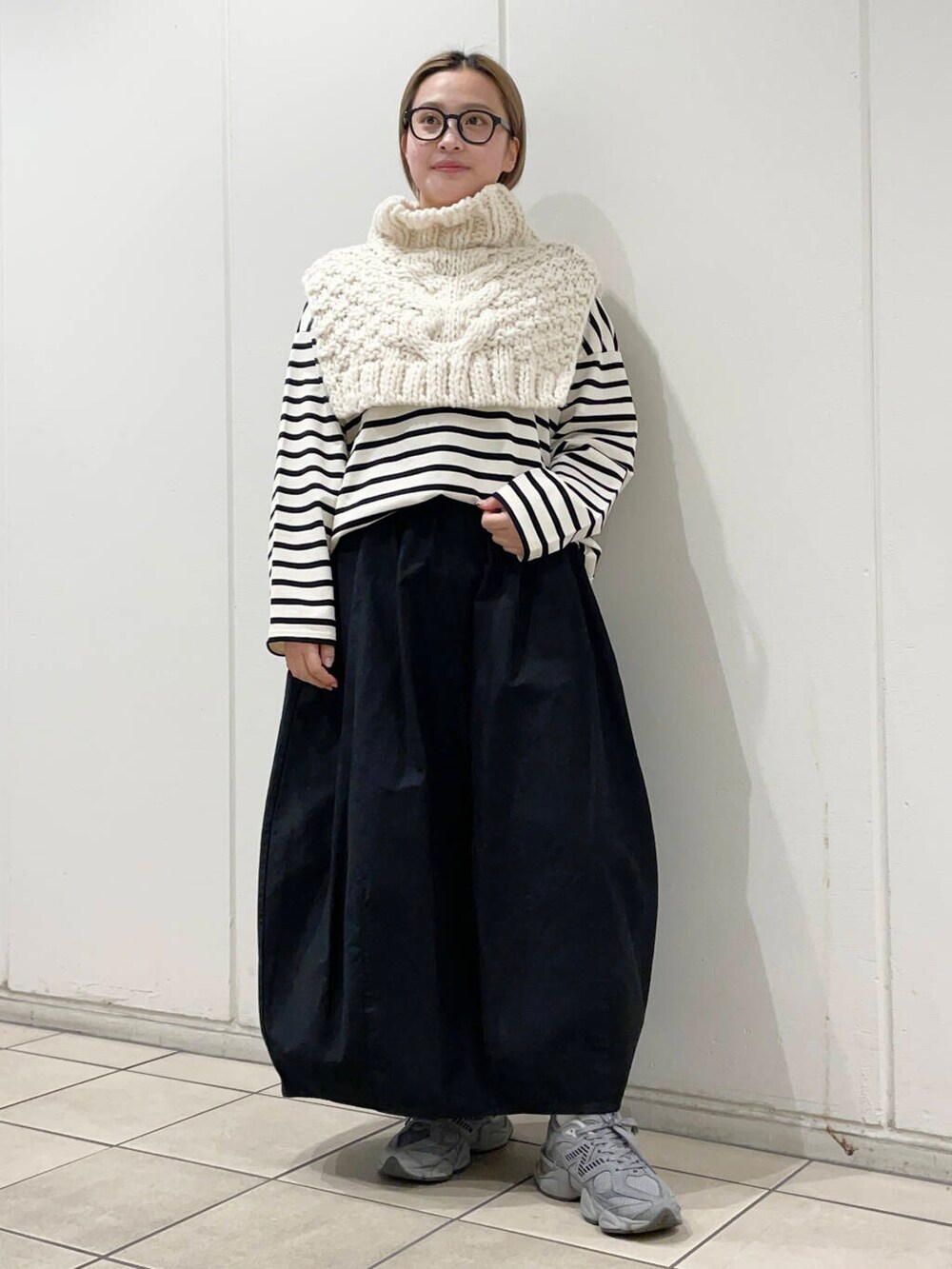 ホワイト系のTシャツ/カットソー、ブラック系のスカート、ホワイト系のネックウォーマー/スヌードを着用したレディースの冬コーディネートの2枚目の写真