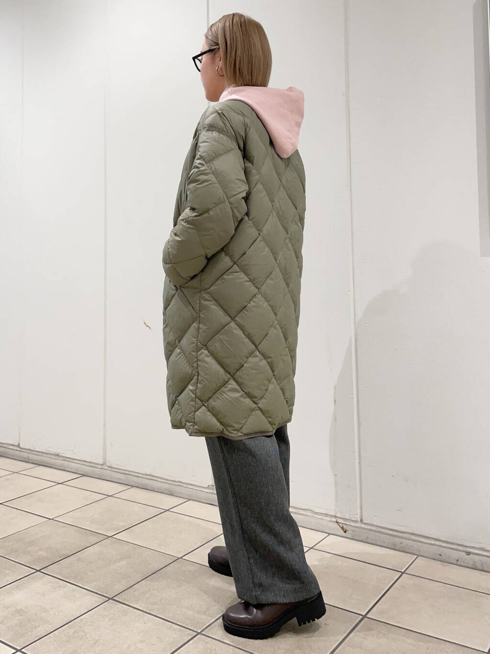 グリーン系のダウンジャケット/コート、グレー系のその他パンツ、ブラウン系のブーツを着用したレディースの秋コーディネートの2枚目の写真