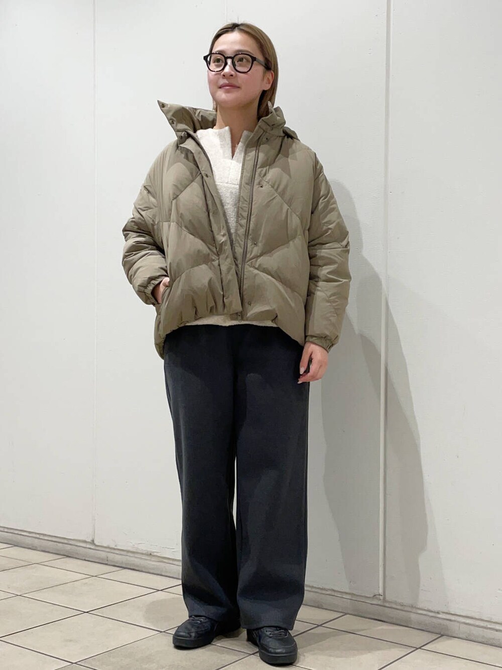 グリーン系のダウンジャケット/コート、グレー系のその他パンツ、ホワイト系のその他トップスを着用したレディースの秋コーディネートの2枚目の写真