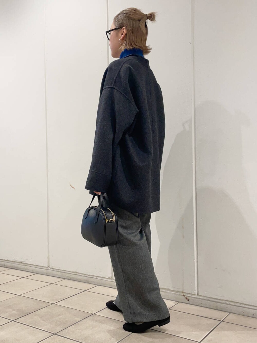 グレー系のその他アウター、グリーン系のニット/セーター、ブラック系のその他シューズを着用したレディースの秋コーディネートの3枚目の写真