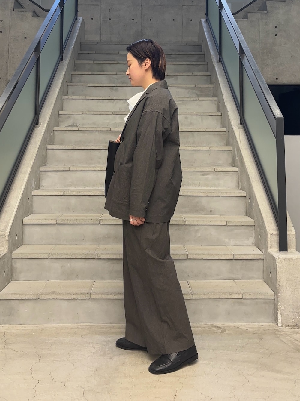 ブラック系のトートバッグ、ブラック系のローファーを着用したレディースの冬コーディネートの2枚目の写真