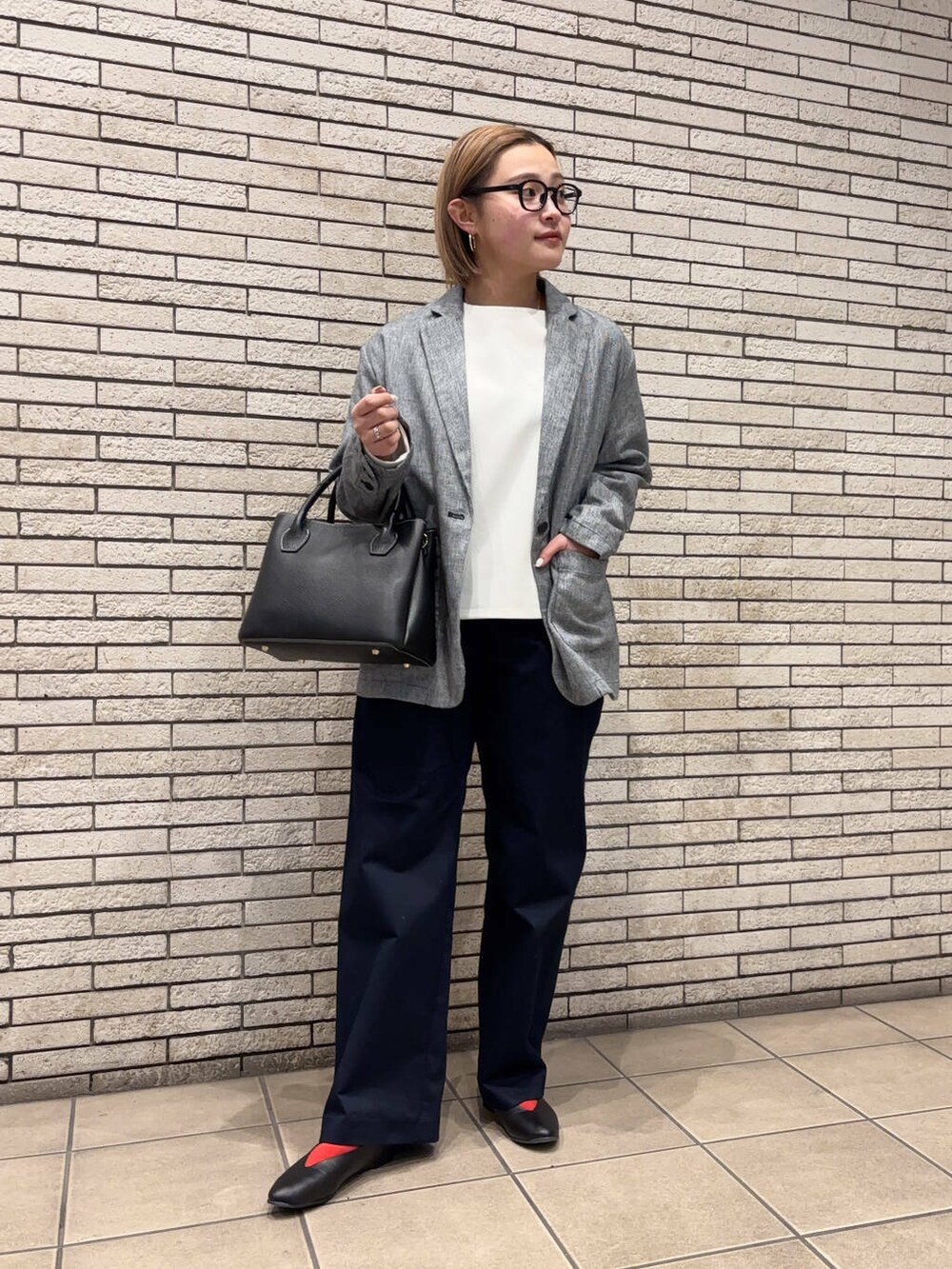 ブラック系のショルダーバッグ、ブラック系のパンプス、ブルー系のその他パンツを着用したレディースの春コーディネートの2枚目の写真