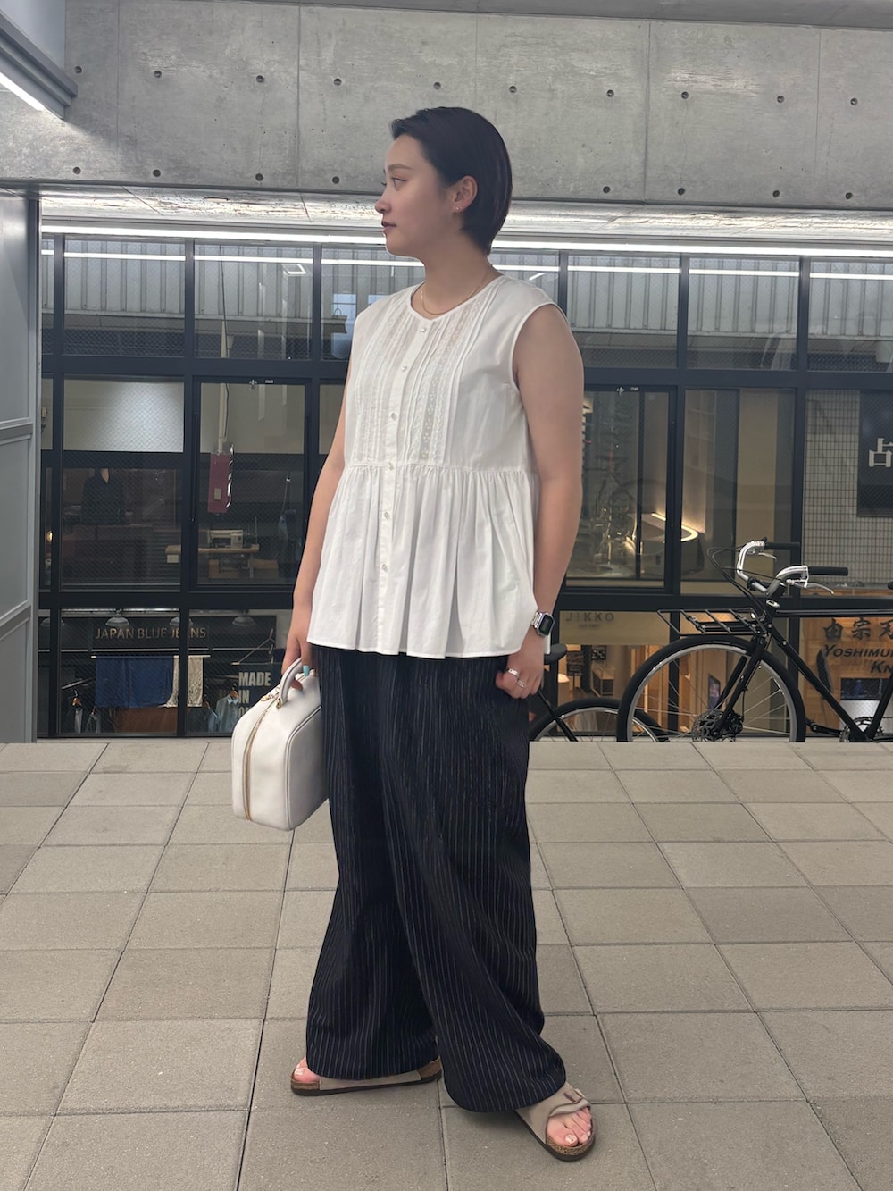 ホワイト系のシャツ/ブラウスを着用したレディースの夏コーディネートの2枚目の写真