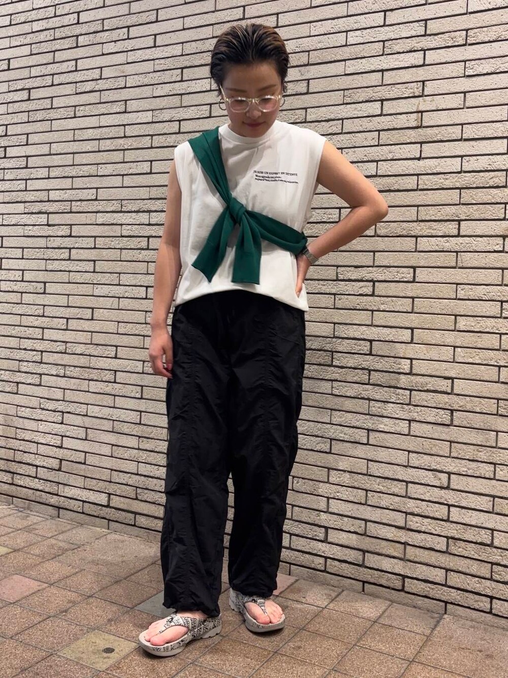 ブラック系のその他パンツ、グリーン系のカーディガン/ボレロ、ホワイト系のTシャツ/カットソーを着用したレディースの夏コーディネートの2枚目の写真