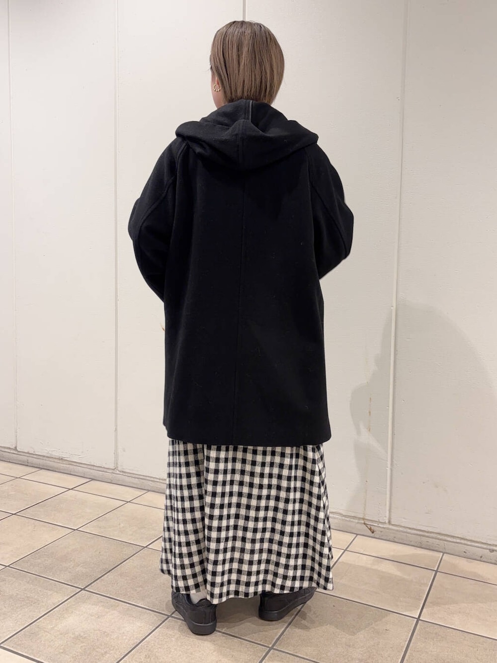 ホワイト系のスカート、ブラック系のその他アウター、ブラック系のニット/セーターを着用したレディースの冬コーディネートの4枚目の写真