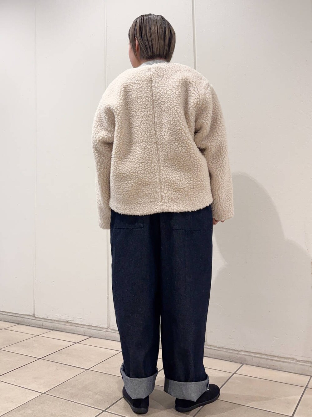 ブラック系のスニーカー、ホワイト系のその他アウター、ブルー系のサロペット/オーバーオールを着用したレディースの冬コーディネートの4枚目の写真