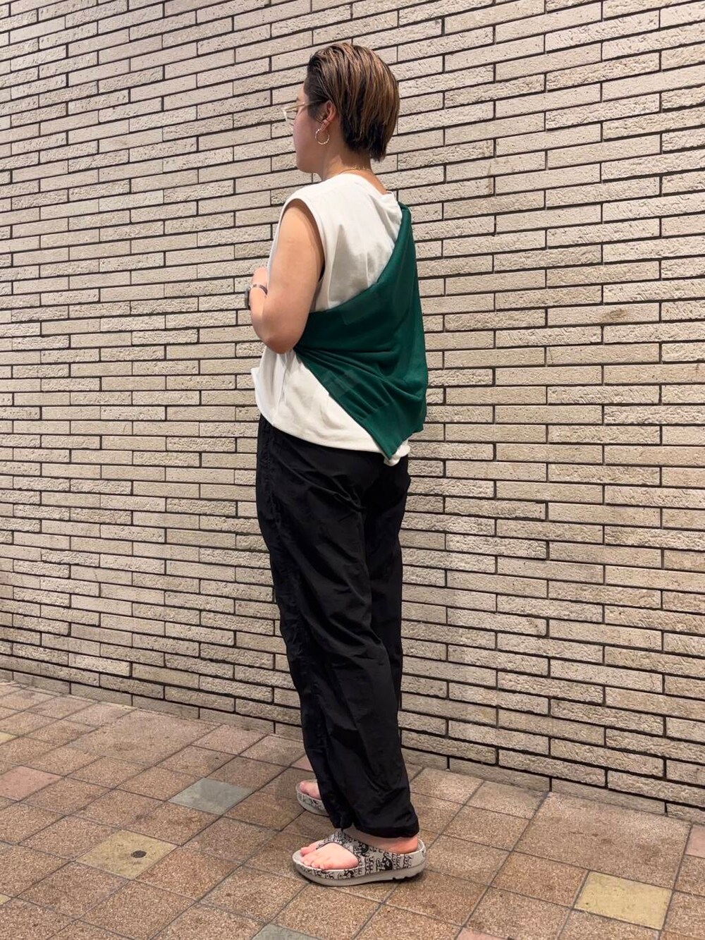 ブラック系のその他パンツ、グリーン系のカーディガン/ボレロ、ホワイト系のTシャツ/カットソーを着用したレディースの夏コーディネートの3枚目の写真