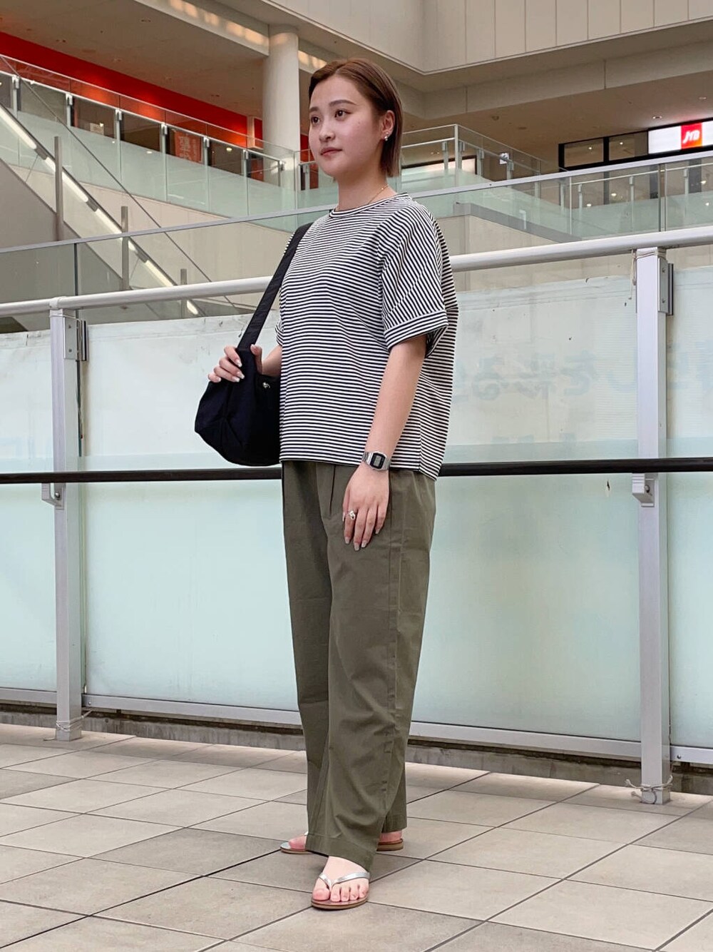 グリーン系のその他パンツ、シルバー系のサンダル、ホワイト系のTシャツ/カットソーを着用したレディースの夏コーディネートの2枚目の写真