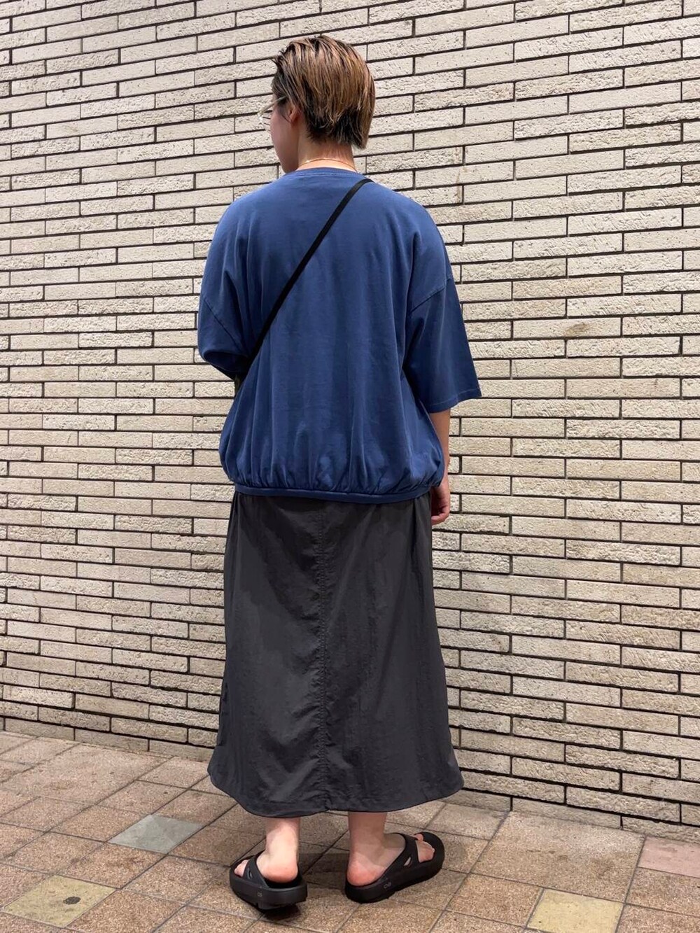 ブラック系のサンダル、グリーン系のショルダーバッグ、グレー系のスカートを着用したレディースの夏コーディネートの4枚目の写真