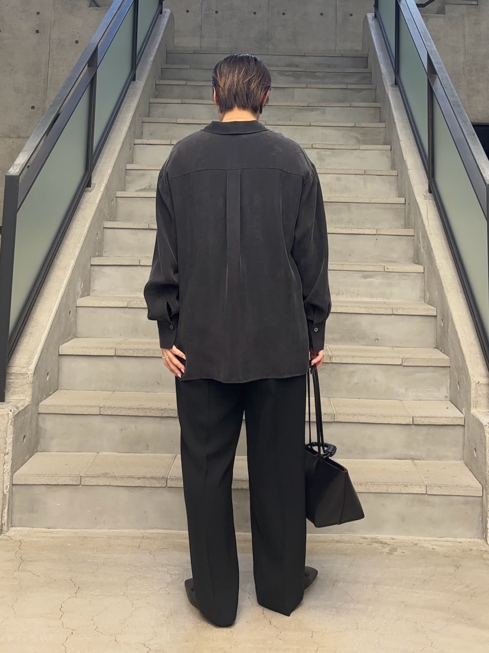 ブラック系のTシャツ/カットソー、ブラック系のトートバッグ、グレー系のシャツ/ブラウスを着用したレディースの冬コーディネートの4枚目の写真