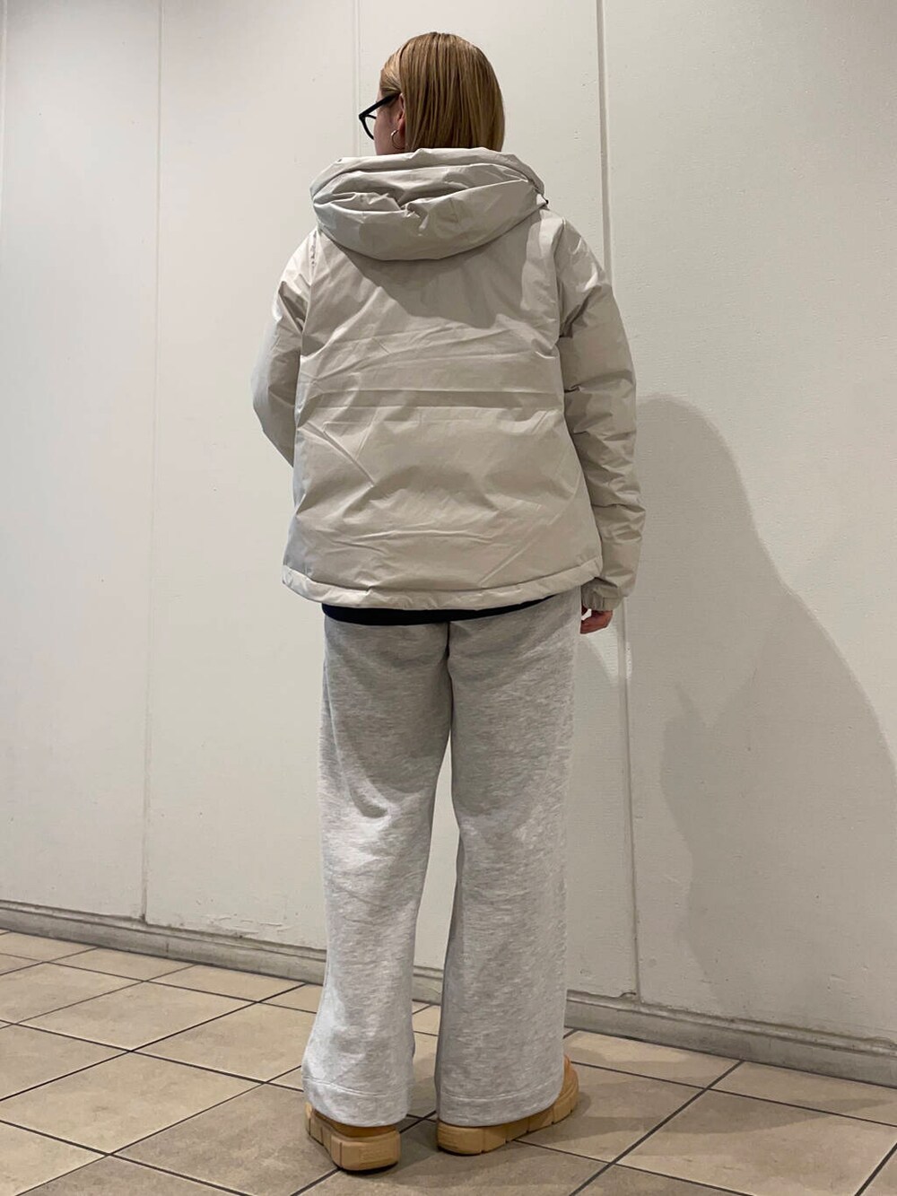 ホワイト系のダウンジャケット/コート、ブルー系のスウェット、グレー系のその他パンツを着用したレディースの秋コーディネートの4枚目の写真