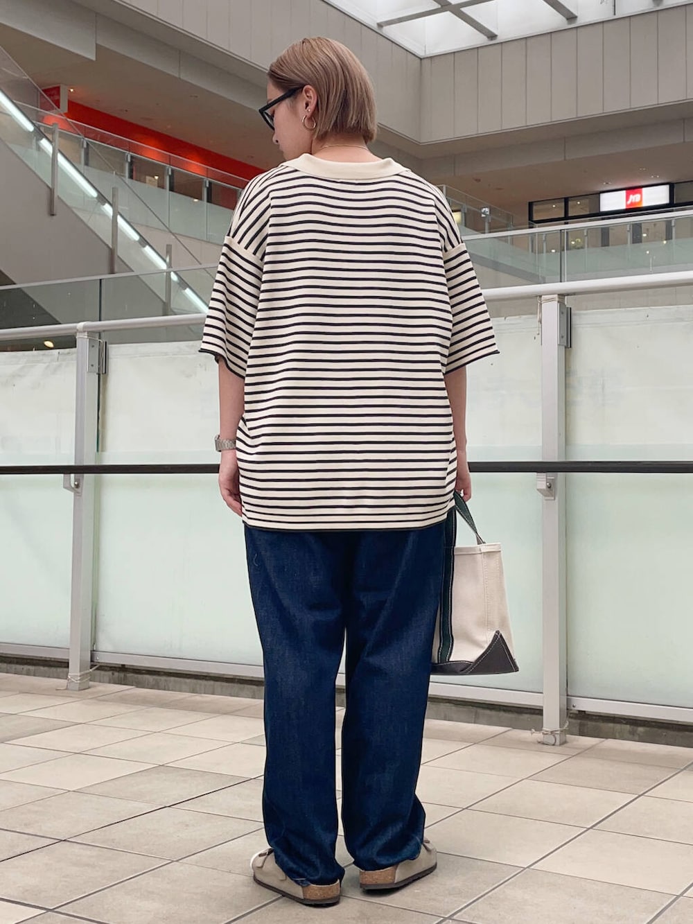 ホワイト系のニット/セーター、ブルー系のデニムパンツ、ホワイト系のトートバッグを着用したレディースの夏コーディネートの3枚目の写真