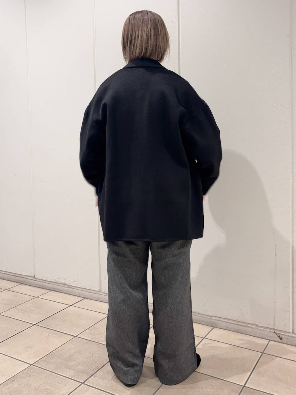 ブラック系のその他アウター、グレー系のその他パンツ、ブルー系のTシャツ/カットソーを着用したレディースの冬コーディネートの3枚目の写真