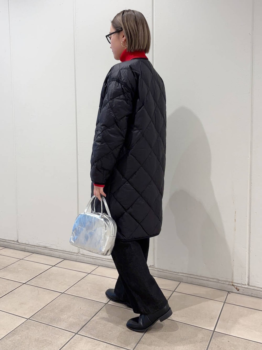 ブラック系のダウンジャケット/コート、ブラック系のサロペット/オーバーオール、ブラック系のブーツを着用したレディースの冬コーディネートの3枚目の写真