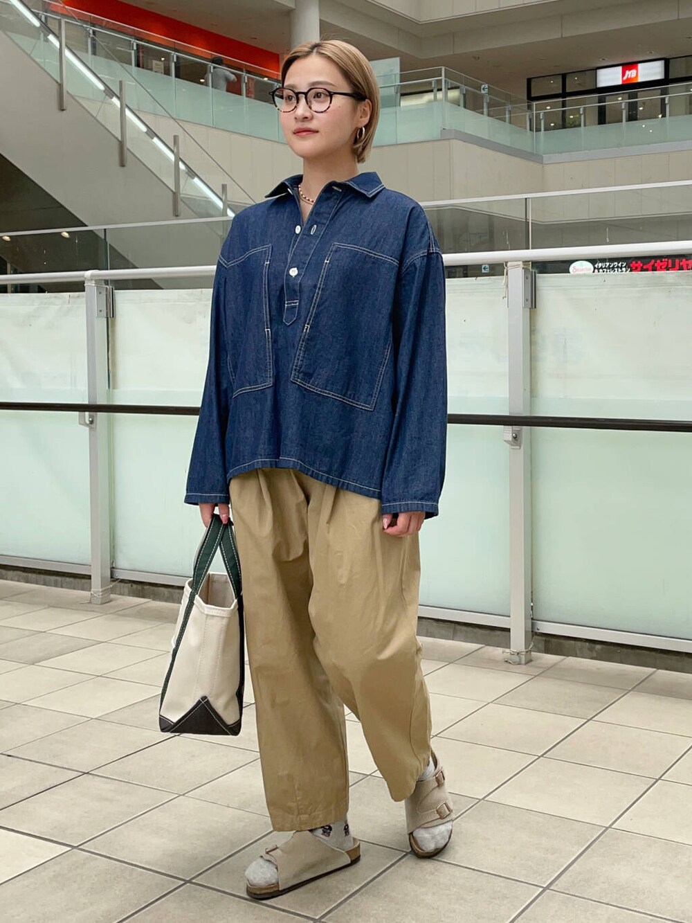 ホワイト系のトートバッグ、ベージュ系のその他パンツ、ブルー系のシャツ/ブラウスを着用したレディースの秋コーディネートの2枚目の写真