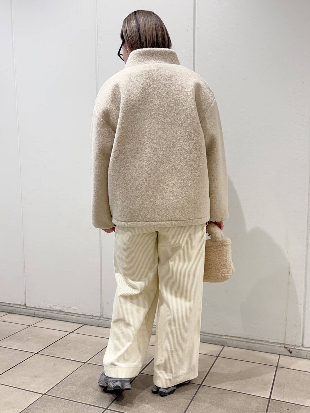 ベージュ系のハンドバッグ、ホワイト系のブルゾン、ホワイト系のその他パンツを着用したレディースの冬コーディネートの4枚目の写真