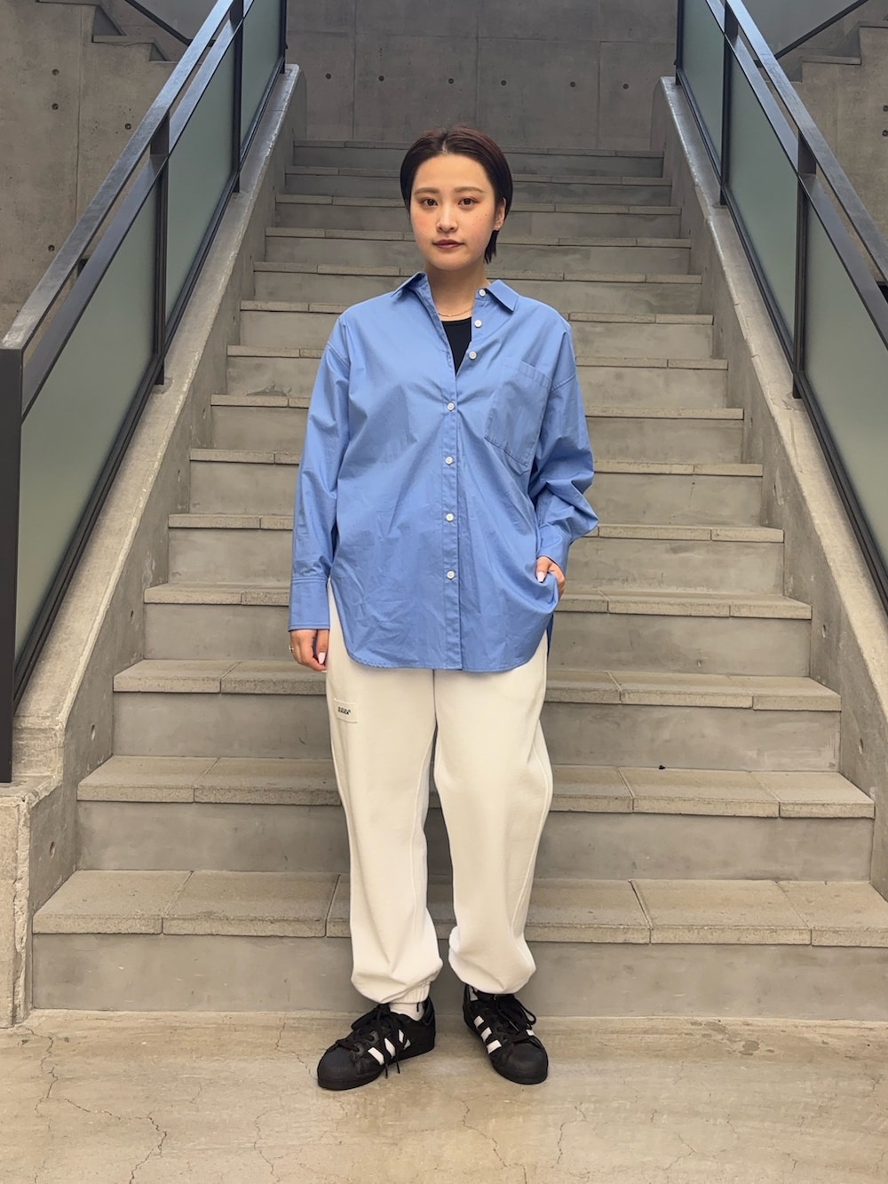 ブルー系のシャツ/ブラウス、ブルー系のタンクトップ、ホワイト系のスウェットパンツを着用したレディースの春コーディネートの2枚目の写真