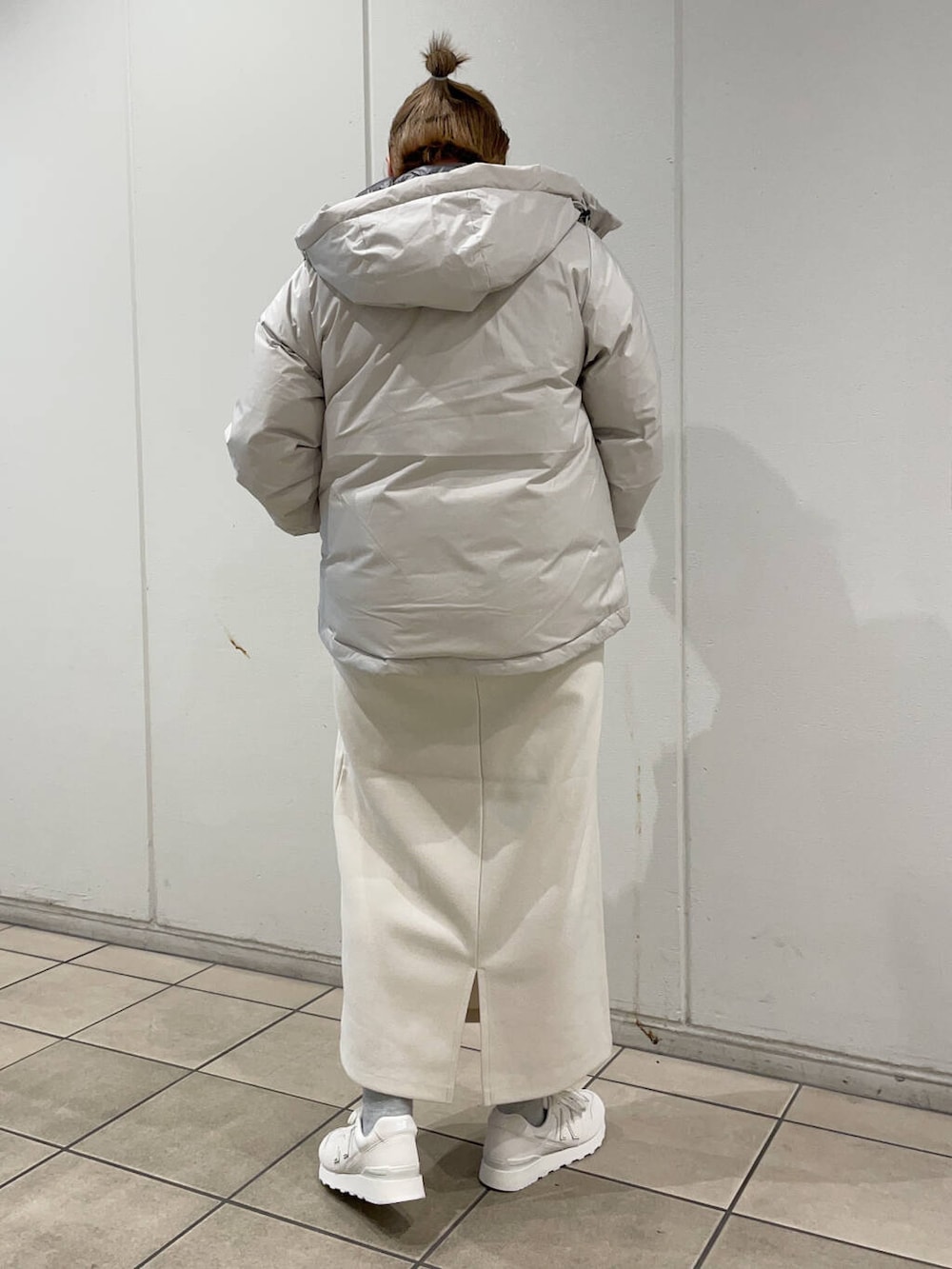 ベージュ系のTシャツ/カットソー、ホワイト系のダウンジャケット/コート、ホワイト系のスカートを着用したレディースの冬コーディネートの3枚目の写真