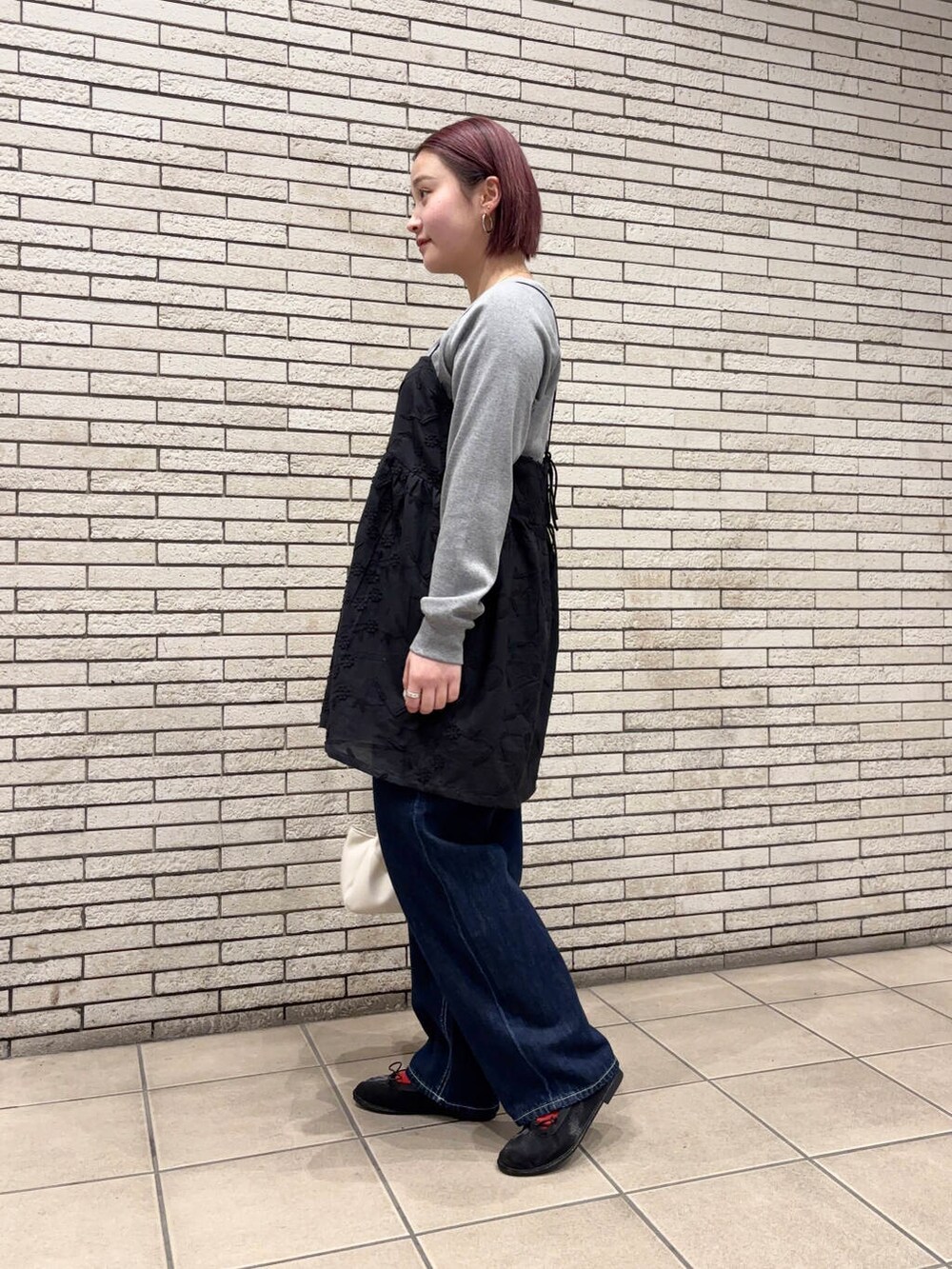 ブラック系のバレエシューズ、ホワイト系のショルダーバッグ、ブルー系のデニムパンツを着用したレディースの春コーディネートの3枚目の写真