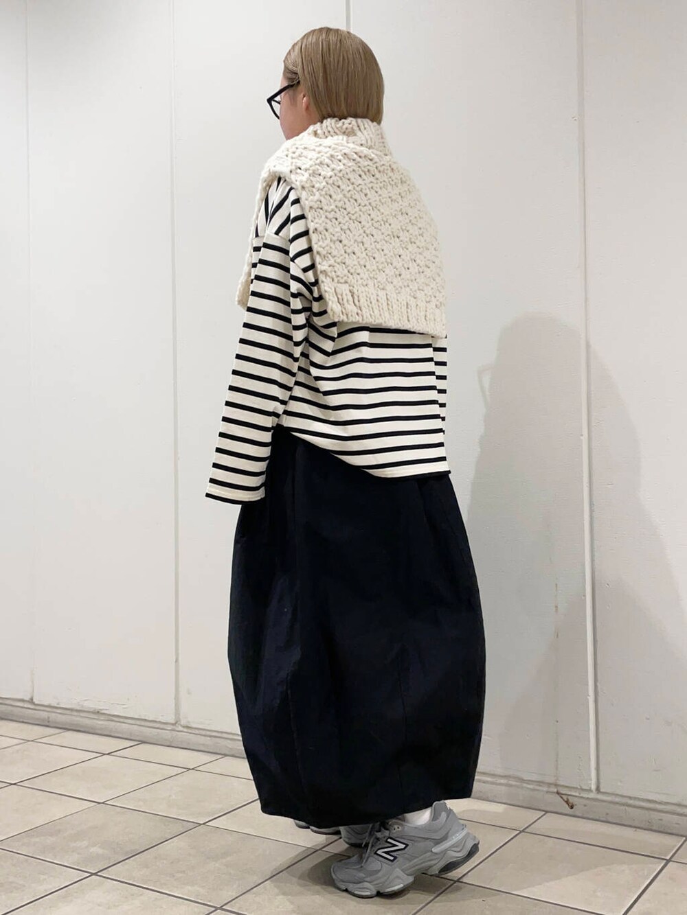 ホワイト系のTシャツ/カットソー、ブラック系のスカート、ホワイト系のネックウォーマー/スヌードを着用したレディースの冬コーディネートの4枚目の写真