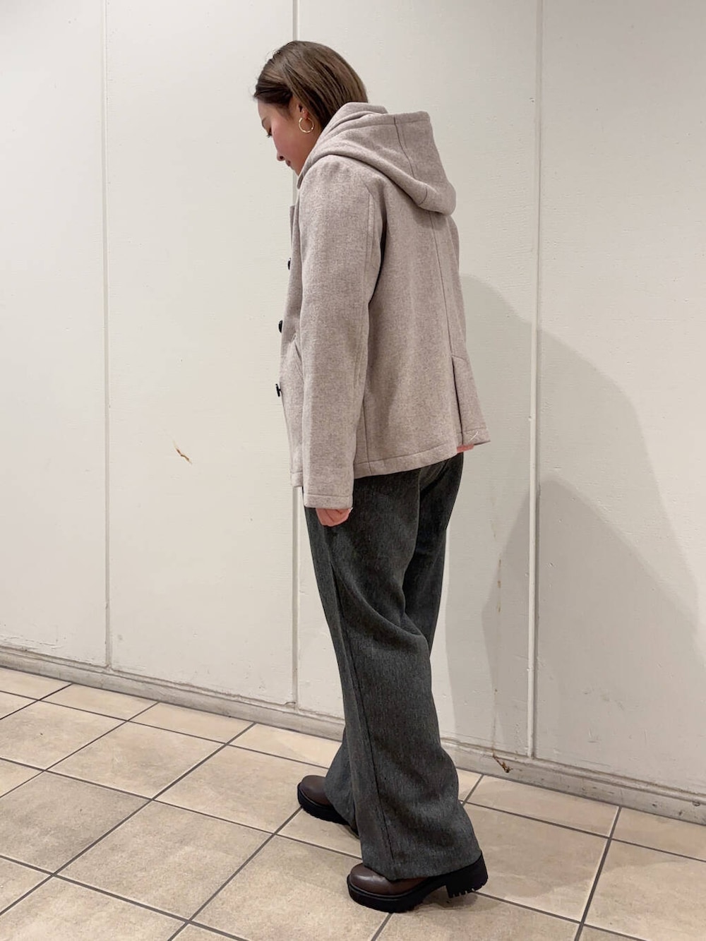 ベージュ系のその他アウター、ピンク系のニット/セーター、グレー系のその他パンツを着用したレディースの冬コーディネートの2枚目の写真