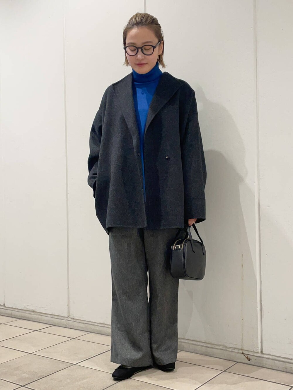 グレー系のその他アウター、グリーン系のニット/セーター、ブラック系のその他シューズを着用したレディースの秋コーディネートの2枚目の写真