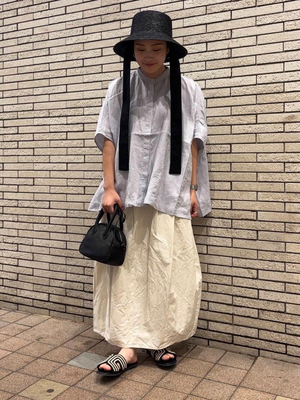 ブラック系のサンダル、パープル系のシャツ/ブラウス、ホワイト系のスカートを着用したレディースの夏コーディネートの2枚目の写真