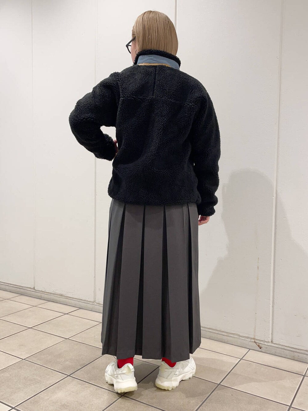 グレー系のスカート、グレー系のスウェット、ブラック系のテーラードジャケットを着用したレディースの秋コーディネートの3枚目の写真