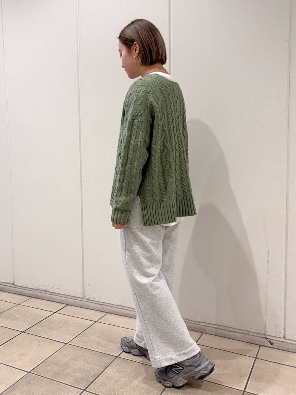 グリーン系のニット/セーター、ホワイト系のTシャツ/カットソー、グレー系のその他パンツを着用したレディースの冬コーディネートの2枚目の写真