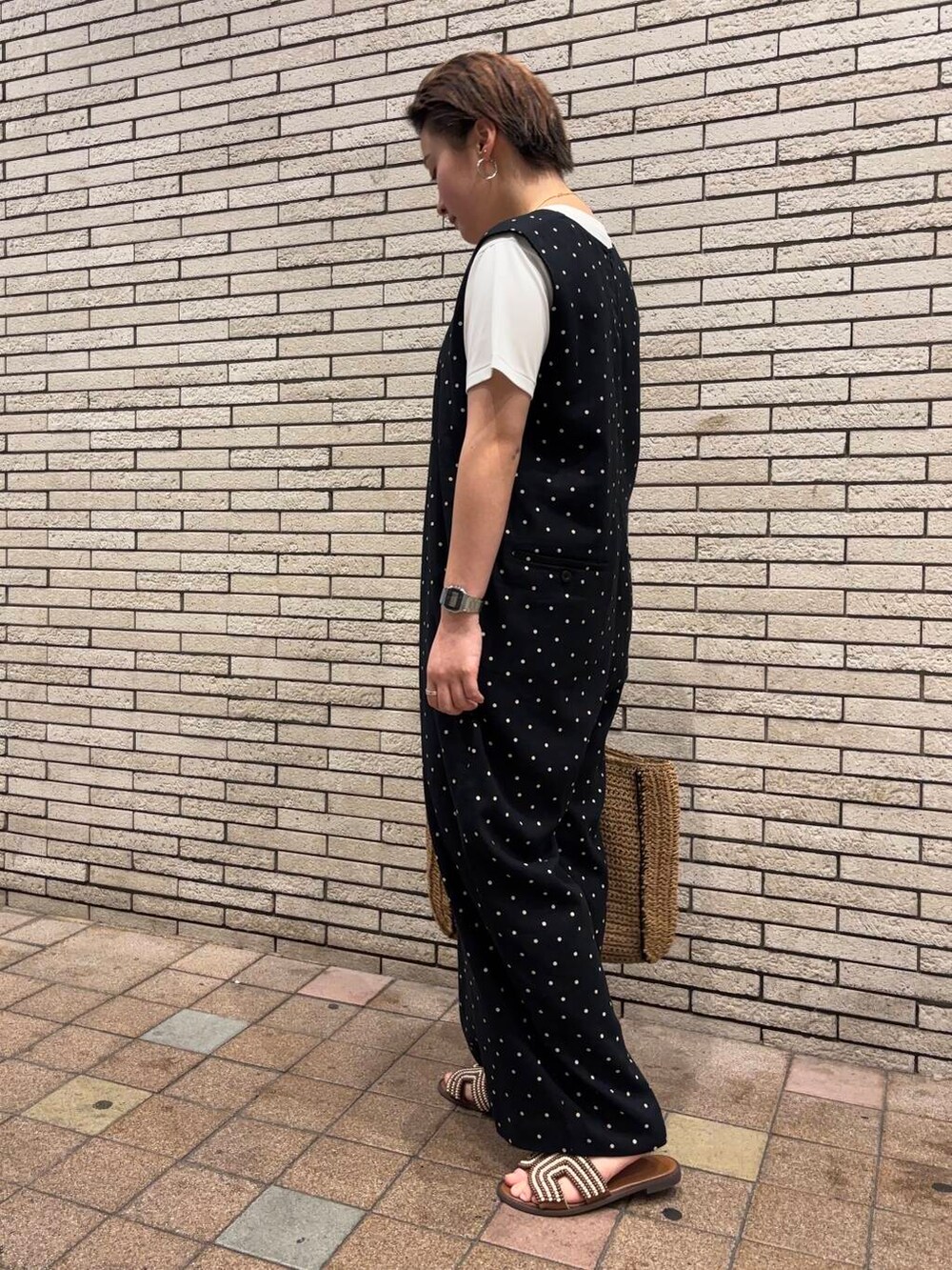 ベージュ系のトートバッグ、ブラック系のサロペット/オーバーオール、ブラウン系のサンダルを着用したレディースの夏コーディネートの3枚目の写真