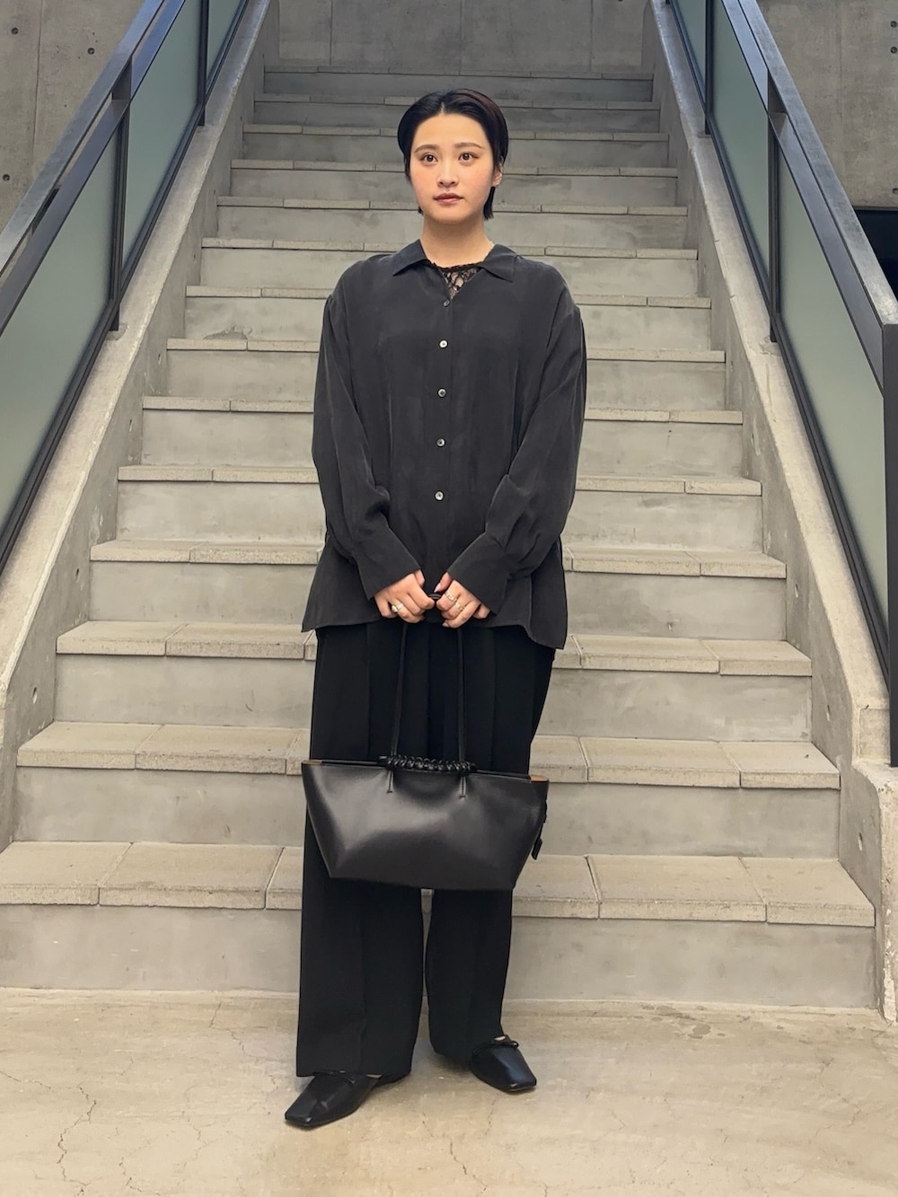 ブラック系のTシャツ/カットソー、ブラック系のトートバッグ、グレー系のシャツ/ブラウスを着用したレディースの冬コーディネートの2枚目の写真