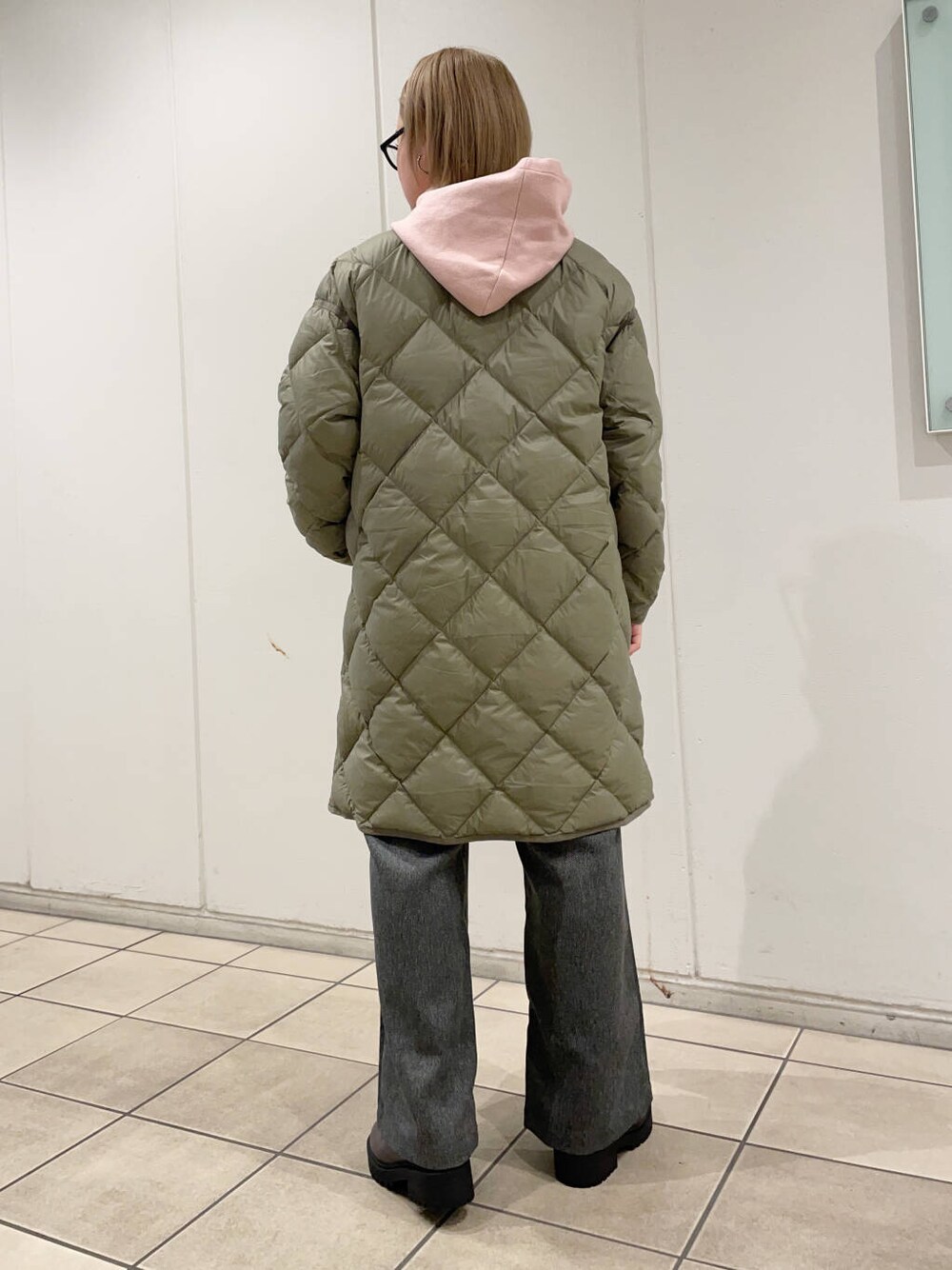 グリーン系のダウンジャケット/コート、グレー系のその他パンツ、ブラウン系のブーツを着用したレディースの秋コーディネートの3枚目の写真