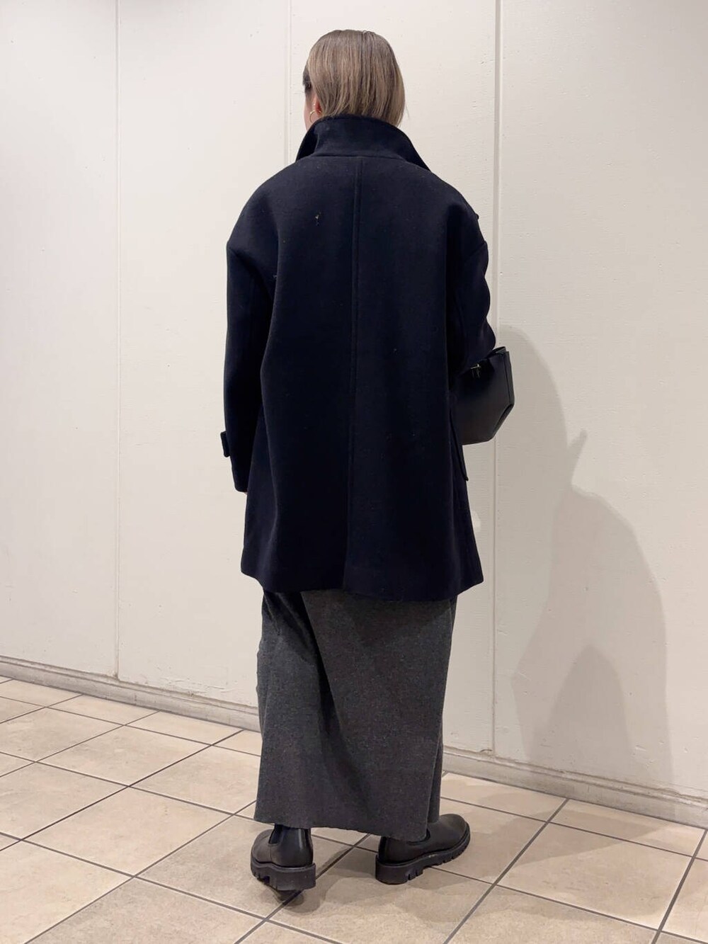 ブラック系のショルダーバッグ、ブルー系のその他アウター、グレー系のワンピースを着用したレディースの冬コーディネートの4枚目の写真