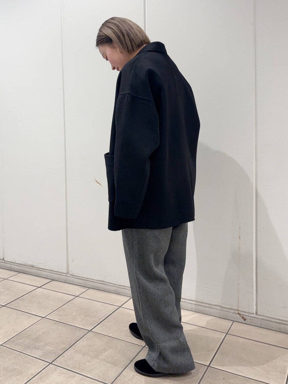 ブラック系のその他アウター、グレー系のその他パンツ、ブルー系のTシャツ/カットソーを着用したレディースの冬コーディネートの2枚目の写真