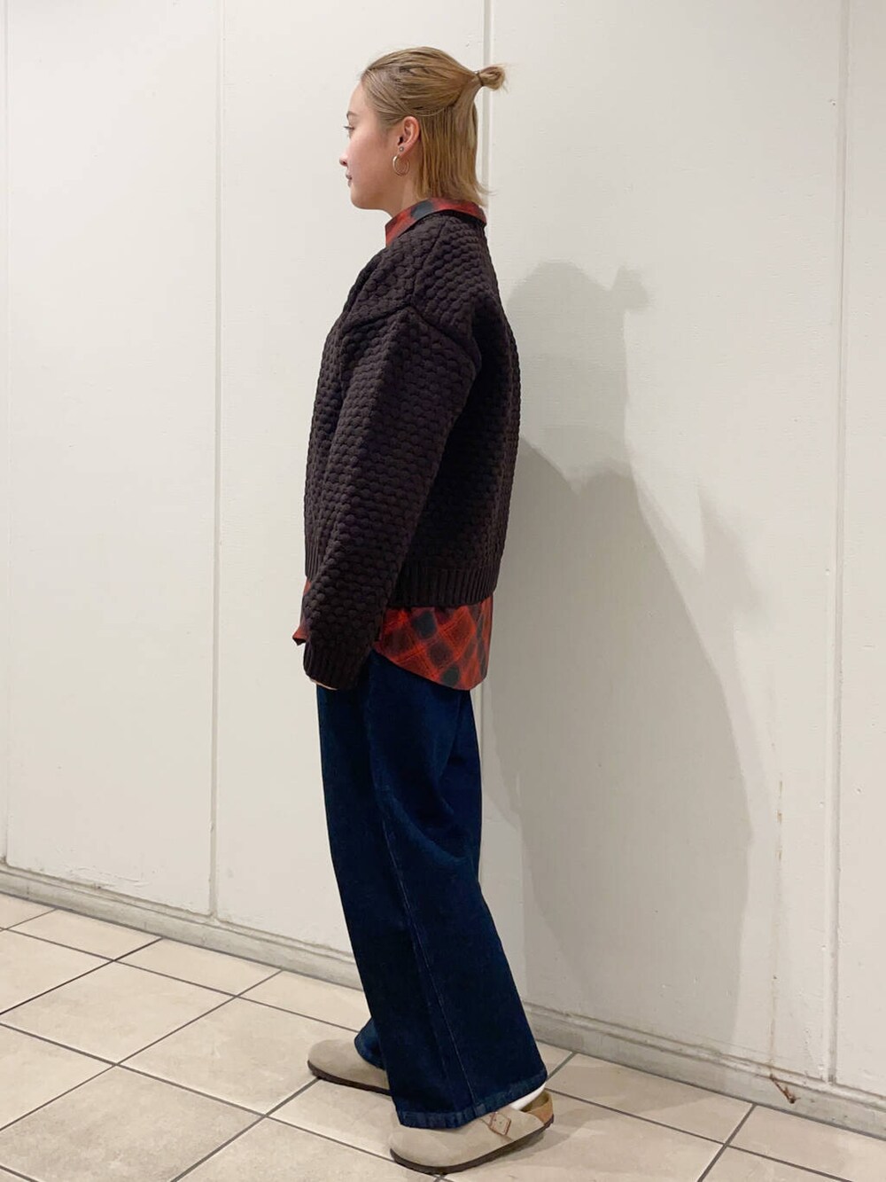 レッド系のシャツ/ブラウス、ブルー系のデニムパンツ、ブラウン系のニット/セーターを着用したレディースの秋コーディネートの2枚目の写真