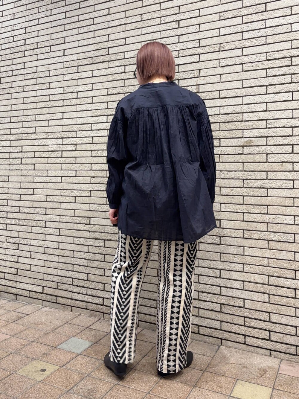 ブラック系のパンプス、ベージュ系のその他パンツ、ブルー系のシャツ/ブラウスを着用したレディースの春コーディネートの3枚目の写真