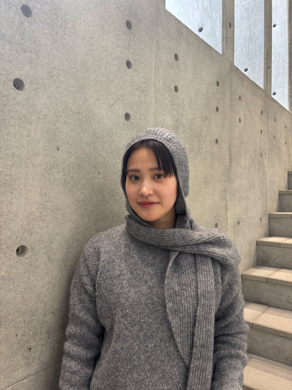 グレー系のニット/セーター、ブルー系のその他パンツ、グレー系のニットキャップ/ビーニーを着用したレディースの秋コーディネートの4枚目の写真
