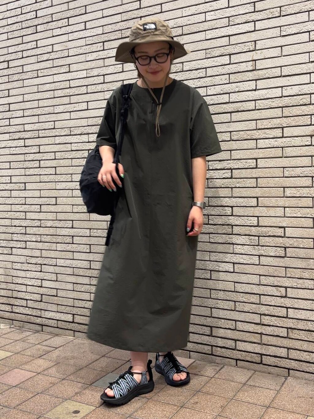 パープル系のサンダル、グリーン系のワンピースを着用したレディースの春コーディネートの2枚目の写真