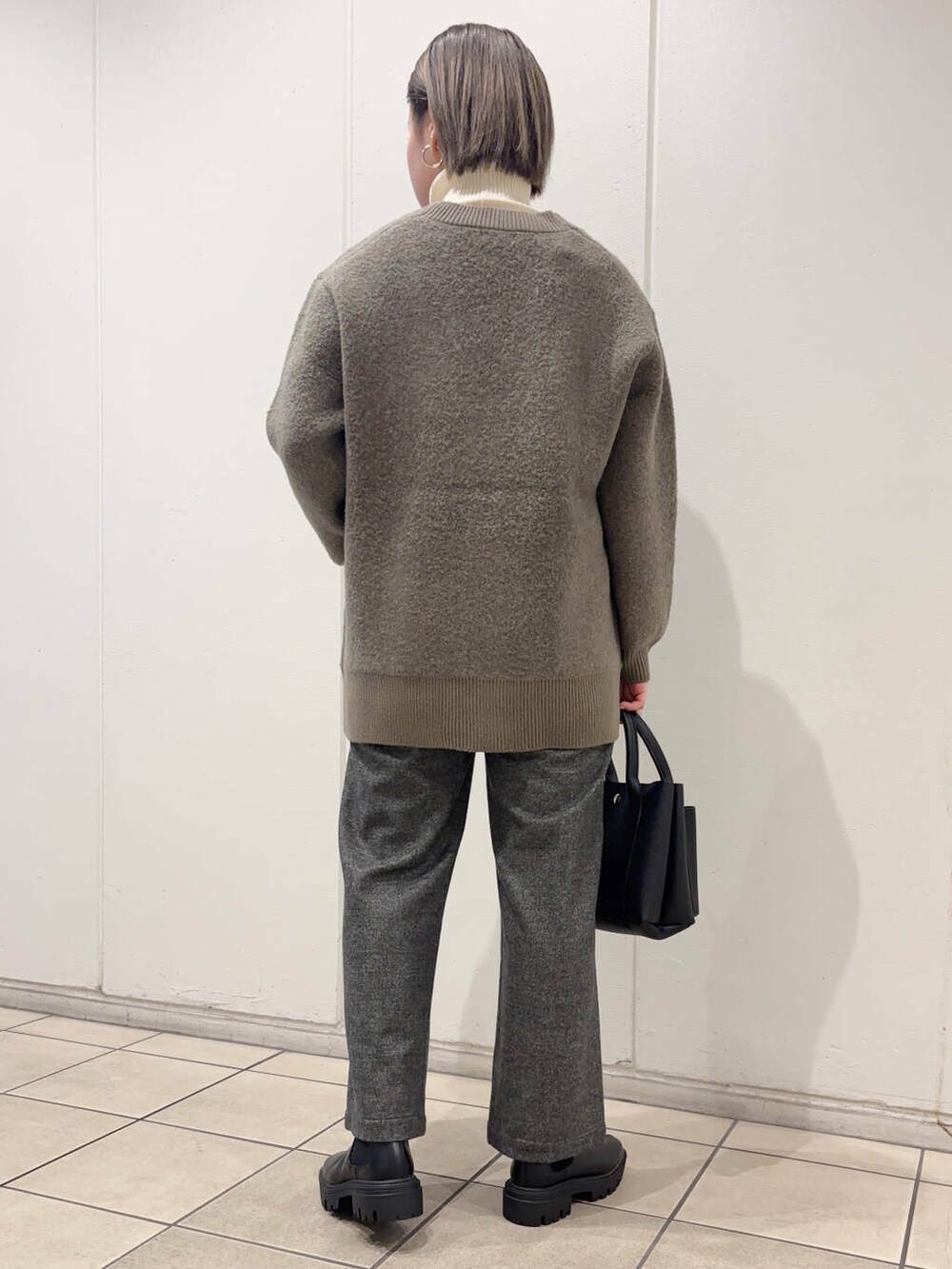 ブラック系のブーツ、ブラウン系のカーディガン/ボレロ、グレー系のその他パンツを着用したレディースの冬コーディネートの3枚目の写真